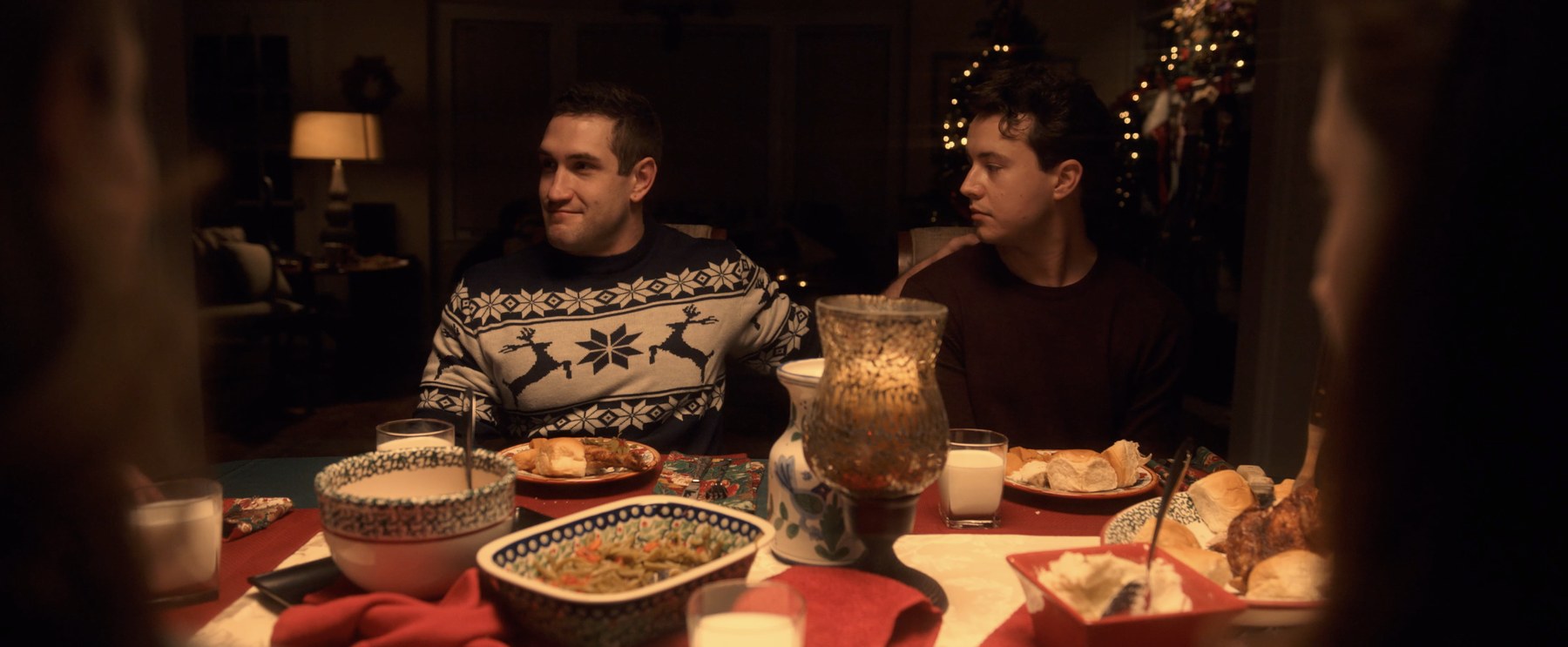 Still from Forgive Us, the two leads at the family Christmas dinner table